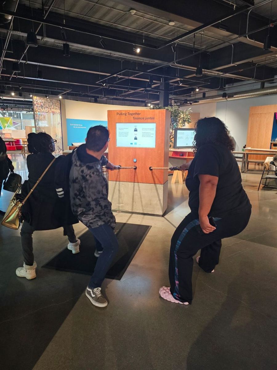 APM participants pulling a rope together at a museum exhibit